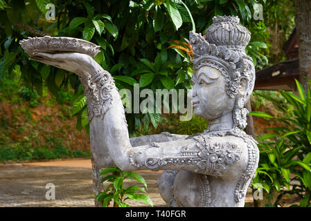 La scultura antica di una ragazza Tailandese con un offerta di Buddha nel tempio buddista la scultura antica di una ragazza Tailandese con un offerta al Buddha Foto Stock