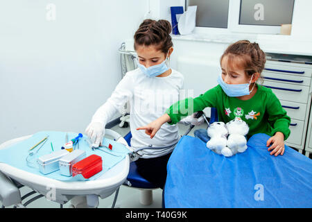 Bambine sono in studio dentistico. Bambini di giocare il gioco e curare i loro denti con i loro giocattoli Foto Stock