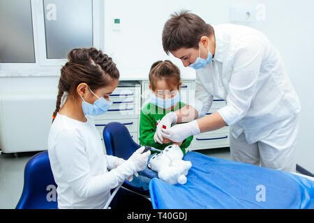 Il medico mostra le bambine la procedura per il trattamento dei denti. Dentista donna salva atmosfera di calma e di purezza specialmente per giovani pati Foto Stock