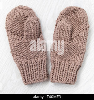 Bellezza beige Guanti a maglia su sfondo bianco. flat laico, vista dall'alto Foto Stock