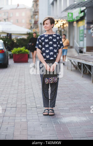 Esterno il corpo completo Ritratto di giovane bella moda donna con piccolo sacchetto di cachi Foto Stock