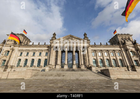 Tedesco bandiere e vista frontale del tedesco del palazzo del parlamento Reichstag di Berlino. Il Reichstag è la sede del Bundestag tedesco dal 1999. Foto Stock