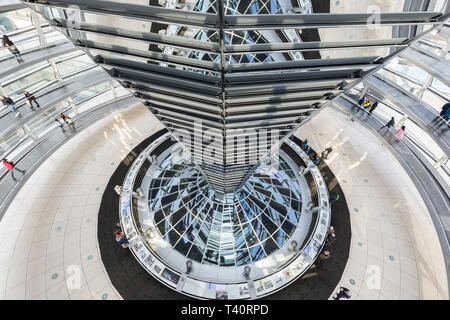 Ad alto angolo di visione del mirroring e del cono interno della futuristica cupola di vetro sulla parte superiore del Reichstag (parlamento tedesco) edificio di Berlino, Germania. Foto Stock