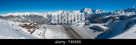 Panoramica vista landscpae del piccolo aeroporto altiport pista sul lato di una coperta di neve catena montuosa alpina in inverno Foto Stock