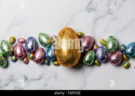Uovo di Pasqua tratta di cioccolato avvolto in lucido foglio colorato Foto Stock