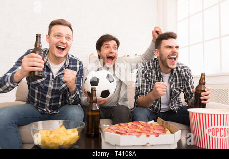 Obiettivo. Felici gli uomini guardando la partita di calcio a casa Foto Stock