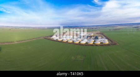 Vista aerea di un grande impianto di produzione di biogas tra il verde dei campi agricoli in Germania - verde energia pulita Foto Stock