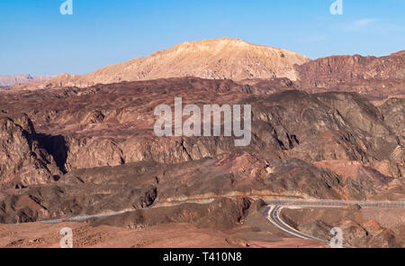 La mattina presto a Israele Egitto confine a eilat montagne che mostra una strada di accesso che termina in corrispondenza del Sinai recinzione di barriera Foto Stock