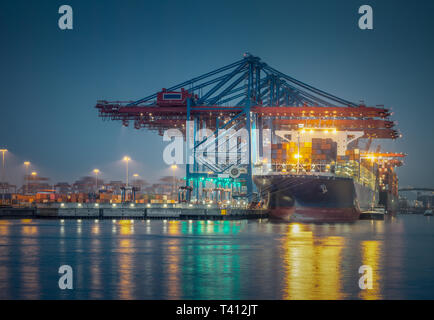 Contenitore nave presso il terminale in la notte nel porto di Amburgo Foto Stock
