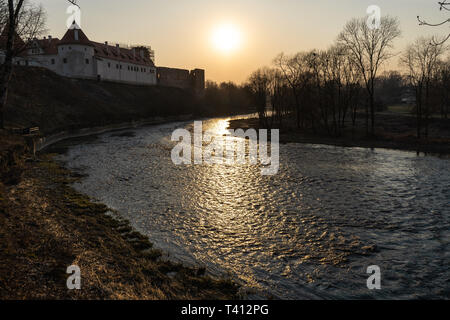 Paesaggio caldo tramonto in un fiume con una molla in esecuzione in acqua Bauska, Lettonia, 2019 Foto Stock