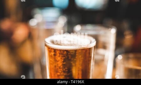 In prossimità di una pinta di birra e bicchieri vuoti su un tavolo Foto Stock