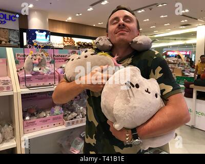 BANGKOK, Tailandia - 16 Aprile 2018: l'uomo gode di peluche Pusheen cat giocattoli in Asia Foto Stock
