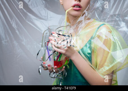 Vaso con plastica. Close up di donna con rosa lip gloss tenendo il vasetto di vetro con supporto in plastica ecologia Foto Stock