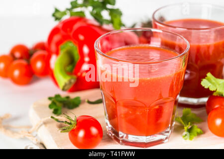 Il pomodoro succhi di verdura in vetro su bianco. Foto Stock