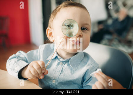 Ritratto di toddler boy lollipop nella sua mano. Foto Stock