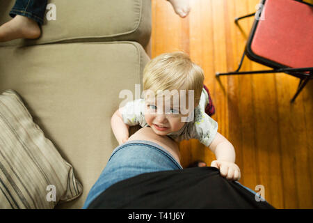 Tipo sirena bionda toddler boy si aggrappa alla madre della gamba durante la ricerca Foto Stock