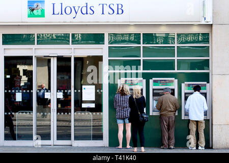 Utilizzando un bancomat presso una filiale di Lloyds TSB. Londra. 01.05.2011. Foto Stock