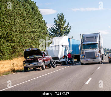 Carrello cambia driver ruota forata del big rig semi camion che trasportano commerciale cargo nel contenitore sul lato della spalla dell'autostrada accanto Foto Stock