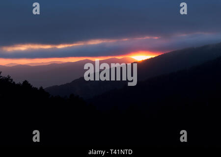 Bel tramonto tra montagne e foreste Foto Stock