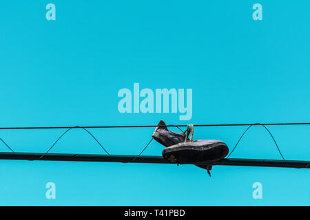 2019, gennaio. Florianópolis, Brasile. Sport scarpe da tennis legato sul filo elettrico contro un cielo blu chiaro. Foto Stock