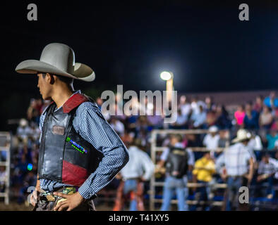 Latin bull riders getting chiamato fuori prima di equitazione in rodeo guatemalteca Foto Stock