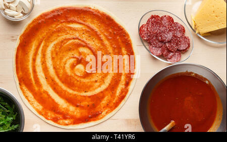 Preparato per pizza. Pasta cruda e ingrediente in ciotole Foto Stock