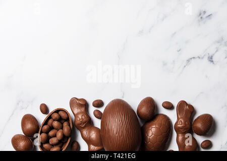 Uova di pasqua di cioccolato e coniglietti su un Sfondo marmo Foto Stock