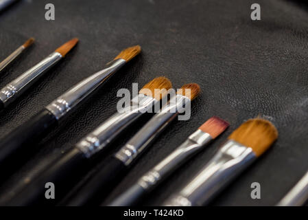 Set di pennelli per il trucco che giace sulla superficie darn vicino Foto Stock