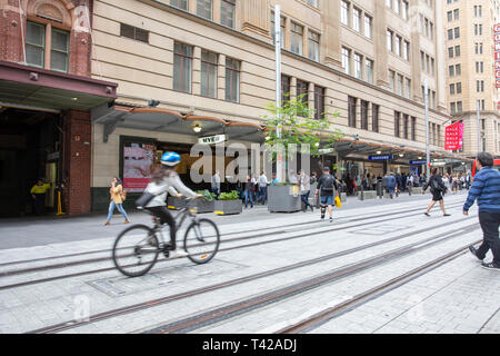 Ciclista passa lungo il completamento della ferrovia leggera le vie di Sydney George street, su una parte completata la rete di tram,Sydney , Australia Foto Stock