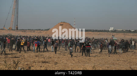 La striscia di Gaza, la Palestina. Xii Apr, 2019. Aprile 12, 2019 - Gaza, Palestina, Palestina - i palestinesi sono visti tenendo il coperchio nel mezzo di gas lacrimogeni sparati dalle forze di Israele durante la dimostrazione vicino al confine con Israele, a est di Khan Yunis nel sud della striscia di Gaza..un ragazzo palestinese è stato ucciso dall'esercito israeliano durante il rinnovato scontri di frontiera Gaza, il ministero della salute nella enclave palestinese ha detto un portavoce del ministero Maysara detto Abu Shaloof, 15, era "hot nello stomaco dall'(israeliana) occupazione a est di Jabalia'', facendo riferimento ad un sito di dimostrazione nel nord della Striscia di Gaza. Credito: Z Foto Stock