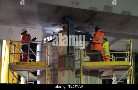 11 aprile 2020, il Land Brandeburgo, Oranienburg: lavoratori edili stand su una impalcatura e assemblare il ponte finito il componente. Sulla parte settentrionale del Berliner Ring A10) tra la giunzione di Birkenwerder e Oranienburg giunzione, i quattro serbatoi di acciaio di un nuovo ponte sono essendo sollevata sul loro nuovo eretto cuscinetti in calcestruzzo mediante gru speciali. I lavoratori stanno lavorando sui sei-lane estensione della A10. A causa della costruzione del ponte di lavoro, l'autostrada sarà completamente chiuso fino a lunedì mattina. Foto: Jan Kiaulehn/dpa-Zentralbild/ZB Foto Stock