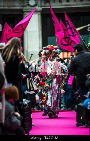 Aprile 12, 2019 - Londra, Londo, Regno Unito - Un attivista uomo visto la presentazione durante l'evento..L'estinzione della ribellione di moda gruppo di azione è andato a Oxford Circus a un fermo dall'allestimento di un creativo e simbolico chiamato passerella moda: Circo di eccesso. L obiettivo è quello di raccogliere l'allarme circa il ruolo del consumo di moda gioca in alimentando il clima e l'emergenza ecologica. Il settore della moda è impostato a consumare un quarto del mondo€™s bilancio di carbonio dal 2050 nella produzione di capi di abbigliamento. (Credito Immagine: © Brais G. Rouco/SOPA immagini via ZUMA filo) Foto Stock