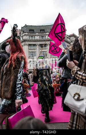 Aprile 12, 2019 - Londra, Londo, Regno Unito - una donna attivista visto la presentazione durante l'evento..L'estinzione della ribellione di moda gruppo di azione è andato a Oxford Circus a un fermo dall'allestimento di un creativo e simbolico chiamato passerella moda: Circo di eccesso. L obiettivo è quello di raccogliere l'allarme circa il ruolo del consumo di moda gioca in alimentando il clima e l'emergenza ecologica. Il settore della moda è impostato a consumare un quarto del mondo€™s bilancio di carbonio dal 2050 nella produzione di capi di abbigliamento. (Credito Immagine: © Brais G. Rouco/SOPA immagini via ZUMA filo) Foto Stock