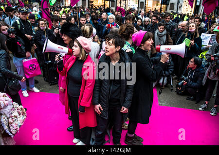 Aprile 12, 2019 - Londra, Londo, Regno Unito - Attivisti sono cantare durante l'evento..L'estinzione della ribellione di moda gruppo di azione è andato a Oxford Circus a un fermo dall'allestimento di un creativo e simbolico chiamato passerella moda: Circo di eccesso. L obiettivo è quello di raccogliere l'allarme circa il ruolo del consumo di moda gioca in alimentando il clima e l'emergenza ecologica. Il settore della moda è impostato a consumare un quarto del mondo€™s bilancio di carbonio dal 2050 nella produzione di capi di abbigliamento. (Credito Immagine: © Brais G. Rouco/SOPA immagini via ZUMA filo) Foto Stock