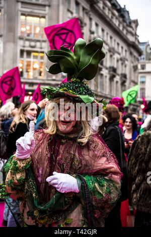 Aprile 12, 2019 - Londra, Londo, Regno Unito - Un attivista uomo visto la presentazione durante l'evento..L'estinzione della ribellione di moda gruppo di azione è andato a Oxford Circus a un fermo dall'allestimento di un creativo e simbolico chiamato passerella moda: Circo di eccesso. L obiettivo è quello di raccogliere l'allarme circa il ruolo del consumo di moda gioca in alimentando il clima e l'emergenza ecologica. Il settore della moda è impostato a consumare un quarto del mondo€™s bilancio di carbonio dal 2050 nella produzione di capi di abbigliamento. (Credito Immagine: © Brais G. Rouco/SOPA immagini via ZUMA filo) Foto Stock