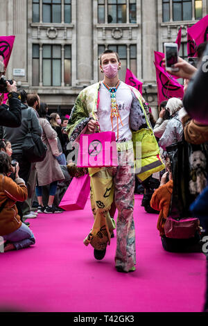 Aprile 12, 2019 - Londra, Londo, Regno Unito - Un attivista uomo visto la presentazione durante l'evento..L'estinzione della ribellione di moda gruppo di azione è andato a Oxford Circus a un fermo dall'allestimento di un creativo e simbolico chiamato passerella moda: Circo di eccesso. L obiettivo è quello di raccogliere l'allarme circa il ruolo del consumo di moda gioca in alimentando il clima e l'emergenza ecologica. Il settore della moda è impostato a consumare un quarto del mondo€™s bilancio di carbonio dal 2050 nella produzione di capi di abbigliamento. (Credito Immagine: © Brais G. Rouco/SOPA immagini via ZUMA filo) Foto Stock