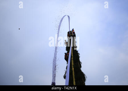 Kathmandu, Nepal. Xiii Apr, 2019. I devoti toss bandiere di preghiera dalla parte superiore del carro di divinità Seto Machindranath sfilando in giro per la città durante il festival chariot a Kathmandu, Nepal, sabato 13 aprile, 2019. Credito: Skanda Gautam/ZUMA filo/Alamy Live News Foto Stock