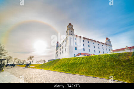 Alone solare oltre il Fiume Danubio e il castello medievale di Bratislava, Slovacchia Foto Stock