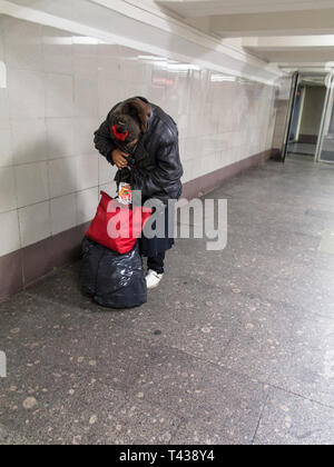 Mosca, Russia - 9/20/2015: senzatetto lady si nasconde la sua faccia finta di essere cernita il pacchetto tra Leningradsky stazione ferroviaria e Komsomolska Foto Stock