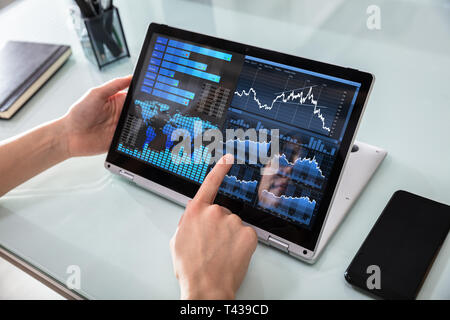 Close-up di una imprenditrice la mano analizzando il grafico su computer portatile digitale al lavoro Foto Stock