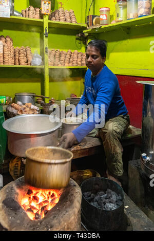 Ritratto verticale di un tradizionale Chai Wallah Vendita di tè dal suo piccolo negozio in Kolkata aka Calcutta, India. Foto Stock