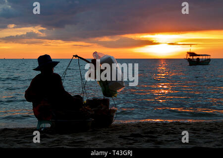 Silhouette di un tradizionale gamberi femmina / Fornitore di gamberi di fiume a Otres Spiaggia (Sihanoukville in Cambogia al tramonto Foto Stock