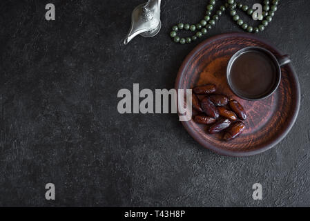 Musulmano tradizionale Iftar cibo sul nero, copia dello spazio. Il Ramadan kareem con premium date e caffè. Il Ramadan iftar concetto alimentare con il rosario. Foto Stock