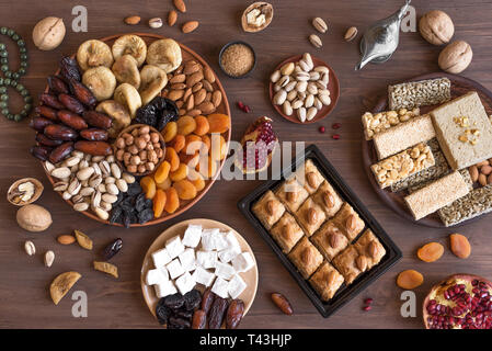 Assortimento, set di Eastern, arabo, turco dolci, frutta a guscio e la frutta secca sulla tavola di legno, vista dall'alto, piatto laici. Holiday Medio Orientale swee tradizionali Foto Stock