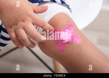 Close-up di ragazza ginocchio con una rosa di bendaggio adesivo Foto Stock