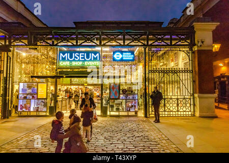 Una famiglia fuori dal London Transport Museum a Covent Garden Piazza di notte, Londra, Regno Unito Foto Stock