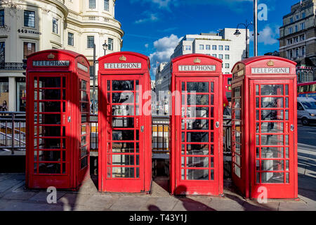 Una fila di caselle telefoniche pubbliche rosse sullo Strand all'incrocio con Duncannon St, Londra, Regno Unito Foto Stock