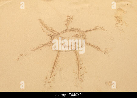 Kid disegnata sun in sabbia bagnata sulla spiaggia. Foto Stock