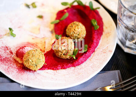 Delizioso Cibo vegetariano falafel con hummus di barbabietole fotografato close-up su un vassoio Foto Stock