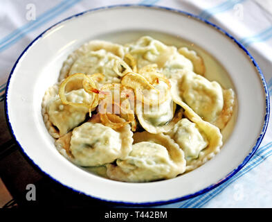 Deliziosi gnocchi di patate con formaggio e cipolle in una ciotola fotografato close-up Foto Stock